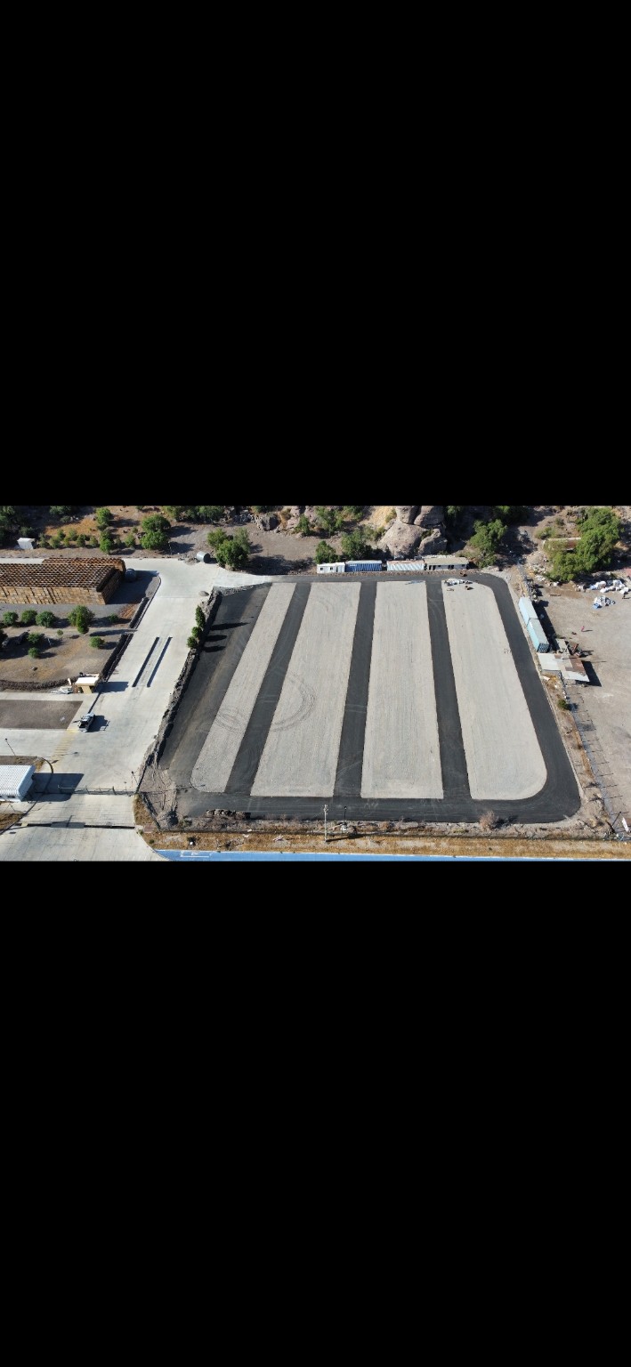 Vista aérea de pavimento asfáltico en una instalación industrial
